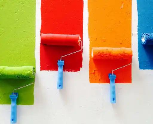 paint four orange, green, blue, and red paint rollers